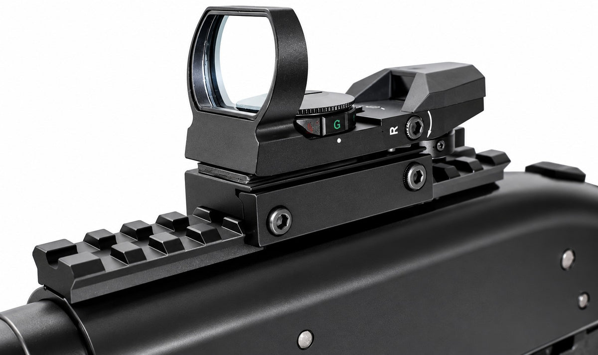 A close-up of a black tactical red dot sight mounted on a black rifle rail, shown against a plain white background.