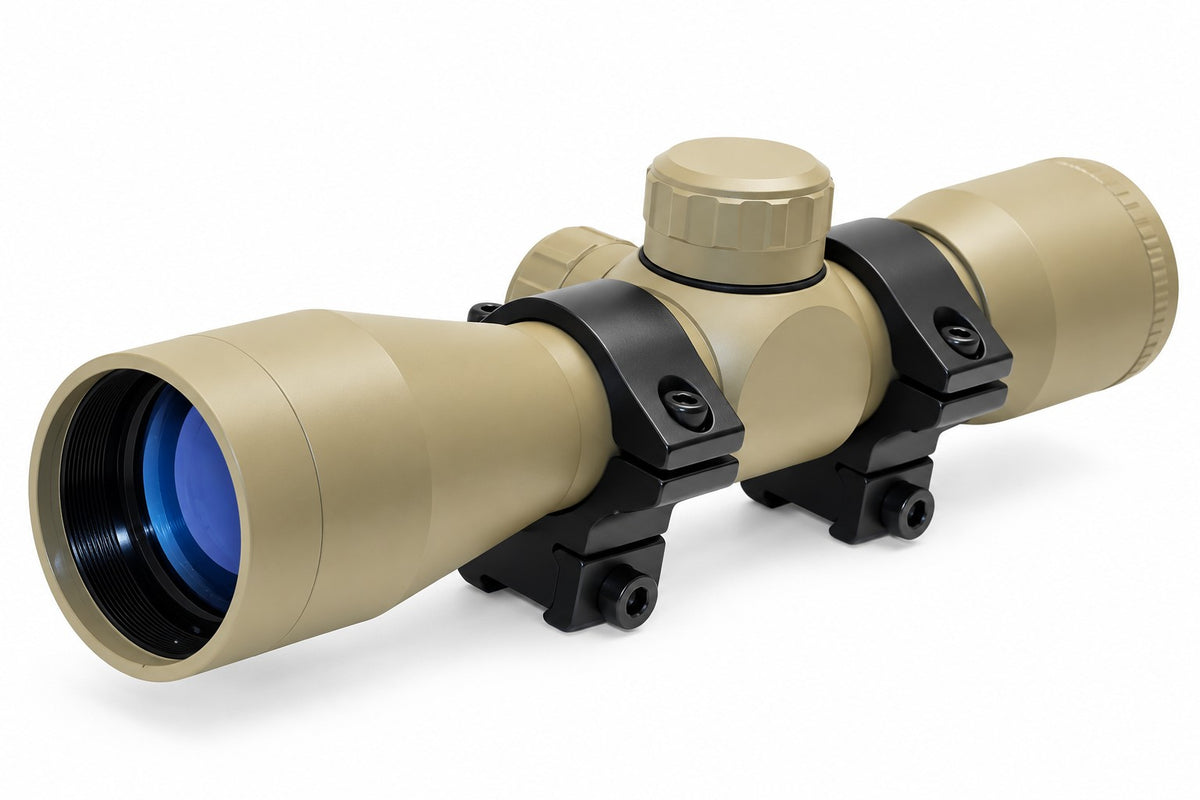 TRINITY 4x32 Mil-Dot scope in tan with blue multi-coated objective lens, aluminum housing, adjustment turrets, and black dovetail mounting rings on a white background.