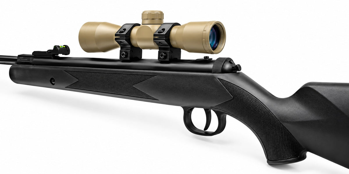 TRINITY 4x32 Mil-Dot scope in tan with blue multi-coated objective lens, aluminum housing, adjustment turrets, and black dovetail mounting rings on a white background.