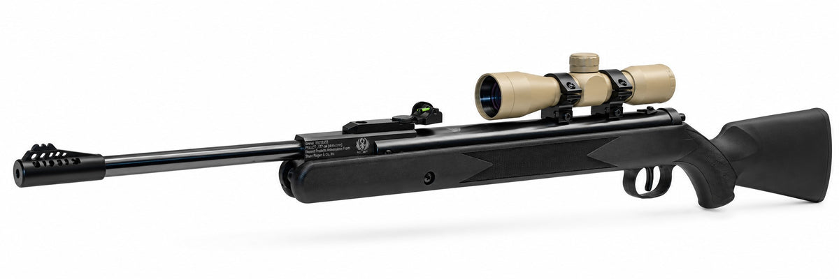 TRINITY 4x32 Mil-Dot scope in tan with blue multi-coated objective lens, aluminum housing, adjustment turrets, and black dovetail mounting rings on a white background.