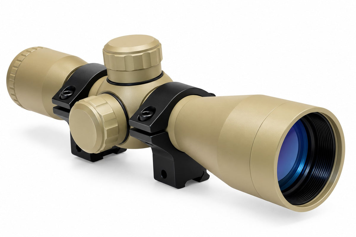 TRINITY 4x32 Mil-Dot scope in tan with blue multi-coated objective lens, aluminum housing, adjustment turrets, and black dovetail mounting rings on a white background.