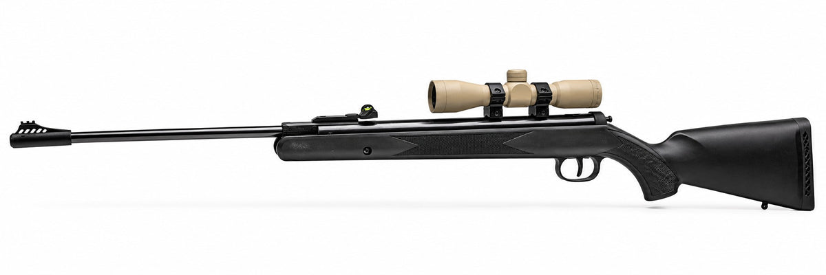 TRINITY 4x32 Mil-Dot scope in tan with blue multi-coated objective lens, aluminum housing, adjustment turrets, and black dovetail mounting rings on a white background.